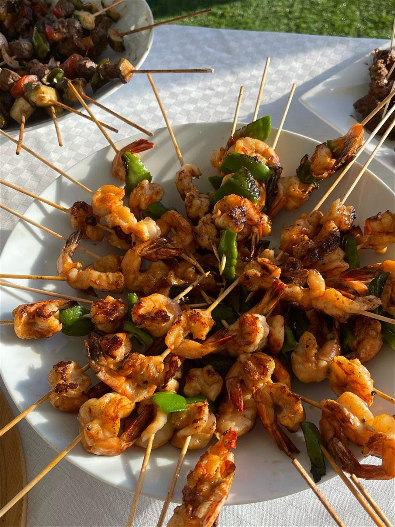 Brochettes de crevettes grillées, servies en assiette.