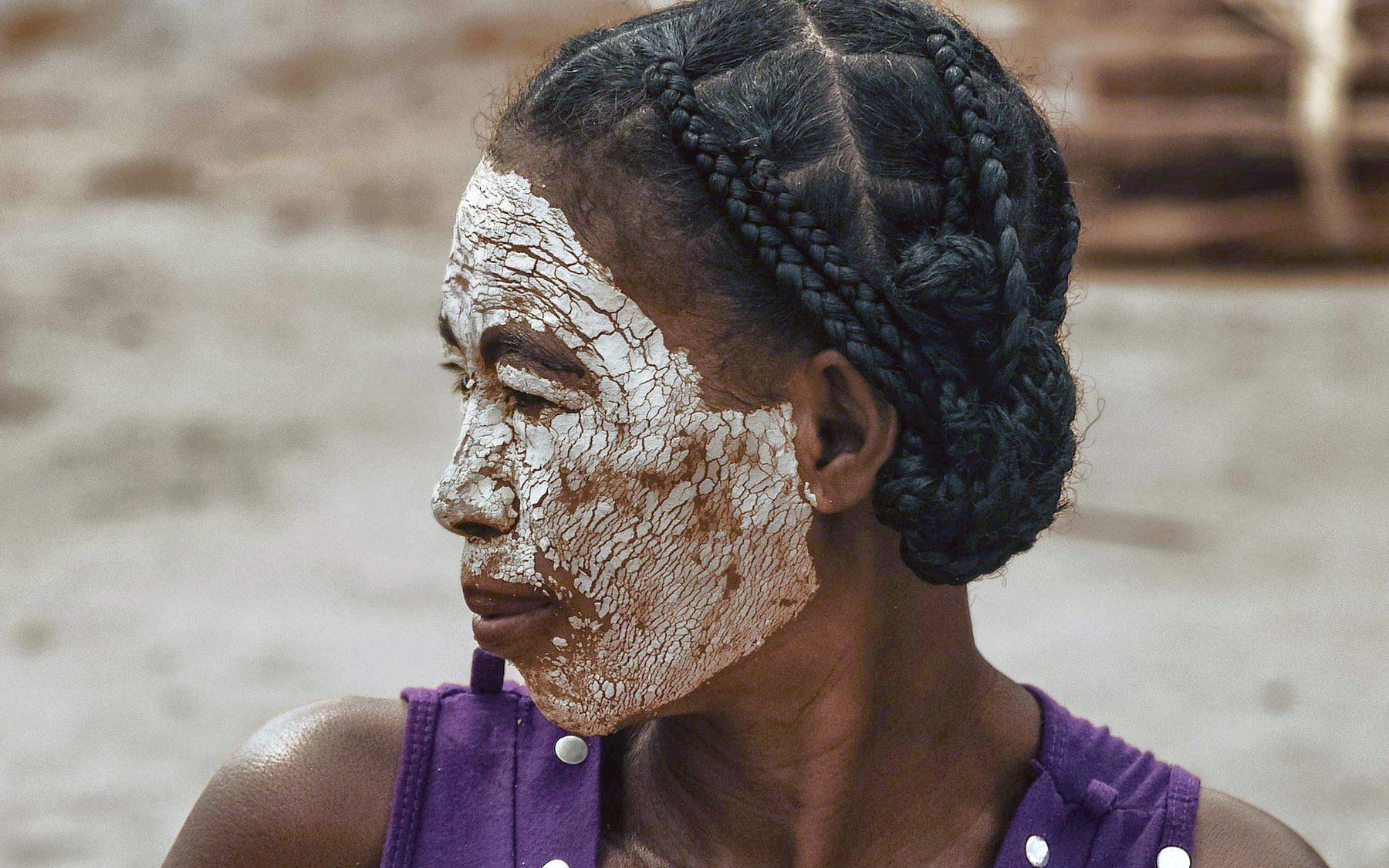 Une femme au visage couvert de masonjoany, la pâte claire tirée d’un bois local, dans un village du Sud-Ouest malgache.